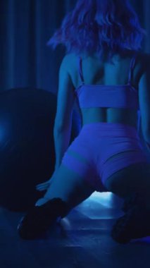 Dikey. Genç bir kadın loş ışıklı neon odada merdivende erotik dans eden bir budala. Yarı tıraşlı bir kız merdivende dikiliyor. Koyu uzayda baştan çıkarıcı bir zarafetle yürüyor. Kulüpte striptiz..