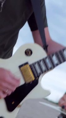 Dikey. Çölde elektro gitar çalmakta sorun yok. Çölde kumların üzerinde bir müzik grubu çalıyor. Profesyonel müzisyen..
