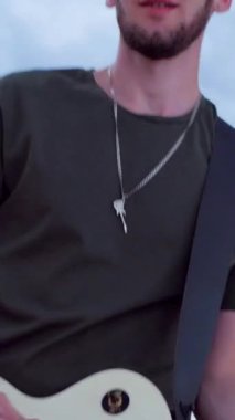 Dikey. Çölde elektro gitar çalmakta sorun yok. Çölde kumların üzerinde bir müzik grubu çalıyor. Profesyonel müzisyen..