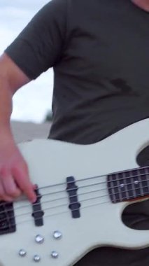 Adam çölde bas gitar çalmakta çok iyi. Çölde kumların üzerinde bir müzik grubu çalıyor. Profesyonel müzisyen..