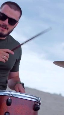 Dikey. Çölde bir müzik grubu çalıyor. Seksi kız bir grupta serin şarkı söyler. Basçı, gitarist, davulcu, profesyonel, konser. Elektro gitar, bas gitar, davul, şarkıcı