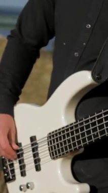 Dikey. Güneşli bir günde bir grup dışarıda canlı çalar. Kadın bir grupta güzel şarkı söylüyor. Grup doğada çalıyor. Basçı, gitarist, davulcu, profesyonel, konser. Güzel manzara.