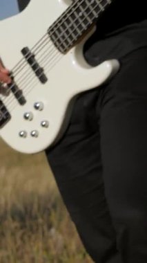 Dikey. Güneşli bir günde bir grup dışarıda canlı çalar. Kadın bir grupta güzel şarkı söylüyor. Grup doğada çalıyor. Basçı, gitarist, davulcu, profesyonel, konser. Güzel manzara.