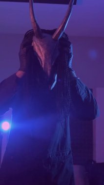 Dikey. Şeytan Canavarlar acı çeker, dans eder, sinirlenir. Karanlık Stüdyo 'da, korkunç maske takmış, kafatası şeklinde gizemli bir adam. Korku, Cadılar Bayramı, Cehennem