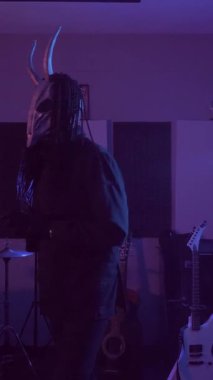 Dikey. Şeytan Canavarlar acı çeker, dans eder, sinirlenir. Karanlık Stüdyo 'da, korkunç maske takmış, kafatası şeklinde gizemli bir adam. Korku, Cadılar Bayramı, Cehennem