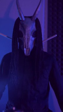 Dikey. Şeytan canavar davul çalıyor. Karanlık bir stüdyoda maskeli gizemli bir adam. Korku, Cadılar Bayramı