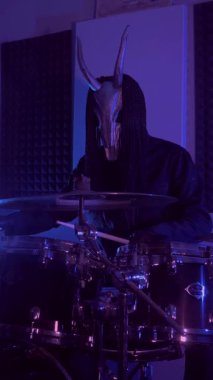 Dikey. Şeytan canavar davul çalıyor. Karanlık bir stüdyoda maskeli gizemli bir adam. Korku, Cadılar Bayramı