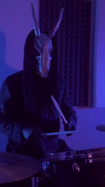 Dikey. Şeytan canavar davul çalıyor. Karanlık bir stüdyoda maskeli gizemli bir adam. Korku, Cadılar Bayramı