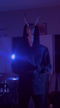 Dikey. Şeytan Canavarlar acı çeker, dans eder, sinirlenir. Karanlık Stüdyo 'da, korkunç maske takmış, kafatası şeklinde gizemli bir adam. Korku, Cadılar Bayramı, Cehennem