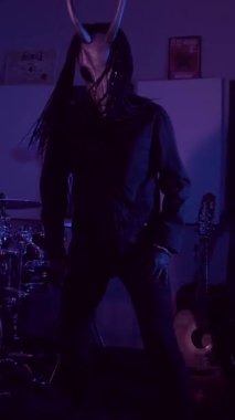 Dikey. Şeytan Canavarlar acı çeker, dans eder, sinirlenir. Karanlık Stüdyo 'da, korkunç maske takmış, kafatası şeklinde gizemli bir adam. Korku, Cadılar Bayramı, Cehennem