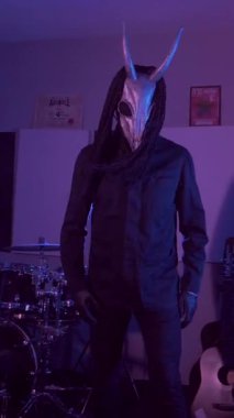 Dikey. Şeytan Canavarlar acı çeker, dans eder, sinirlenir. Karanlık Stüdyo 'da, korkunç maske takmış, kafatası şeklinde gizemli bir adam. Korku, Cadılar Bayramı, Cehennem