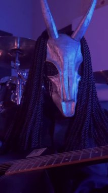 Dikey. Şeytan canavar gitar çalıyor. Karanlık bir stüdyoda maskeli gizemli bir adam. Korku, Cadılar Bayramı, Cehennem