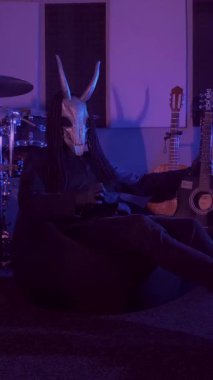 Dikey. Şeytan canavar gitar çalıyor. Karanlık bir stüdyoda maskeli gizemli bir adam. Korku, Cadılar Bayramı, Cehennem