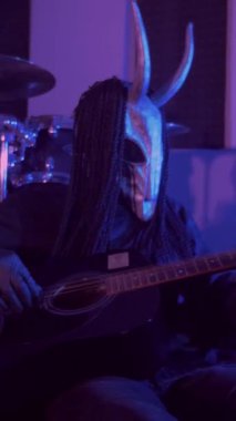 Dikey. Şeytan canavar gitar çalıyor. Karanlık bir stüdyoda maskeli gizemli bir adam. Korku, Cadılar Bayramı, Cehennem