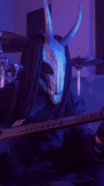 Dikey. Şeytan canavar gitar çalıyor. Karanlık bir stüdyoda maskeli gizemli bir adam. Korku, Cadılar Bayramı, Cehennem