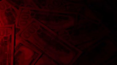 Canlı bir Amerikan para akışı var. Çok renkli ışıkta yıkanmış bir Amerikan doları yağmuru. ABD banknotlarının yakın plan görüntüsü. Detayları renkli bir renge bürünmüş. kağıt para döner.
