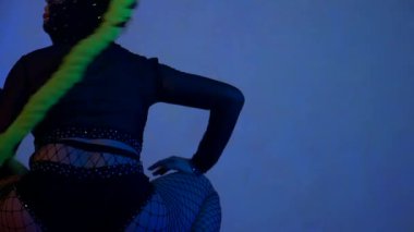 Seksi kızlar erotik dans eder. Kadınlar twerk dansı yapar. Dansçı stüdyoda cinsel olarak hareket eder. Maskeli dansçılar, dengeli ve dinamik, loş sahneyi yönetiyorlar. Neon renkli gölgeler büyüleyici bir hareketle sanatçılarla dans ediyor..