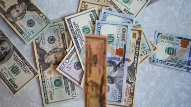 Bir yığın gevrek, dolar banknotları, becerikli ellerde tutuluyor. Adam kağıt para sayıyor. Bir Amerikan para akışı. Bir sürü Amerikan doları. ABD banknotlarının yakın plan görüntüsü. İşadamı elindeki banknotları sayar. Elinde parası olan adam..
