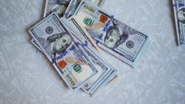 Bir yığın gevrek, dolar banknotları, becerikli ellerde tutuluyor. Adam kağıt para sayıyor. Bir Amerikan para akışı. Bir sürü Amerikan doları. ABD banknotlarının yakın plan görüntüsü. İşadamı elindeki banknotları sayar. Elinde parası olan adam..
