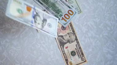 Bir yığın gevrek, dolar banknotları, becerikli ellerde tutuluyor. Adam kağıt para sayıyor. Bir Amerikan para akışı. Bir sürü Amerikan doları. ABD banknotlarının yakın plan görüntüsü. İşadamı elindeki banknotları sayar. Elinde parası olan adam..