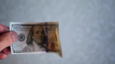 Bir yığın gevrek, dolar banknotları, becerikli ellerde tutuluyor. Adam kağıt para sayıyor. Bir Amerikan para akışı. Bir sürü Amerikan doları. ABD banknotlarının yakın plan görüntüsü. İşadamı elindeki banknotları sayar. Elinde parası olan adam..
