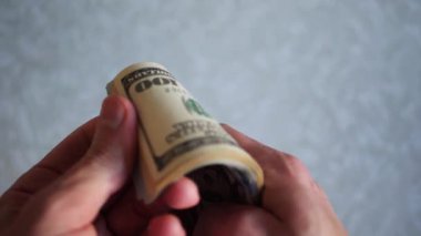 Bir yığın gevrek, dolar banknotları, becerikli ellerde tutuluyor. Adam kağıt para sayıyor. Bir Amerikan para akışı. Bir sürü Amerikan doları. ABD banknotlarının yakın plan görüntüsü. İşadamı elindeki banknotları sayar. Elinde parası olan adam..