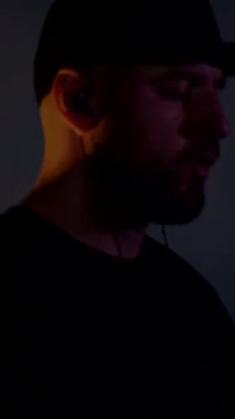 Dikey. Davulcu cool rock konserini çalar. Bir adam sahnede enerjik bir şekilde davul çalıyor arkasında parlak ışıklar yanıyor. Canlı performans sergileyen bir davulcu. Etrafı renkli sahne ışıklarıyla çevrili. Tutkuyla davul çalan bir adam 