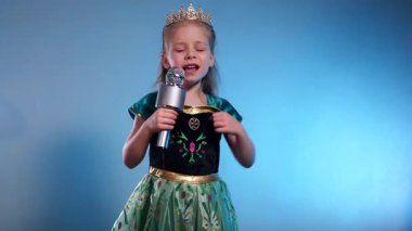 Küçük bir prenses, yükselen bir ses, büyüleyici bir performans. Kraliçe mikrofona şarkı söyleyip dans ediyor. Karaoke. Zümrüt bir elbise, parlak bir taç, küçük bir yıldız adayı sahneye çıkıyor. Elleri mikrofona yapıştırılmış, geleceğin yıldızı.. 
