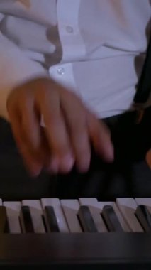 Dikey. Adam stüdyoda sentezleyici çalıyor. Elektrikli piyano. İplerin ve pulların makro çekimi. Müzik grubu restoranda çalar. Gece romantik bir ışıktır. Caz, Blues, Funk Retro