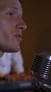 Dikey. Adam stüdyoda şarkı söylüyor ve gitar çalıyor. Müzik grubu restoranda çalar. Gece romantik bir ışıktır. Caz, Blues, Funk A vokalisti şarkı söylüyor. Retro