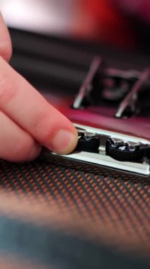 Dikey. Bir el titizlikle bavulun şifresini belirler ve değerli kargoyu güvene alır. Seyahat bavulu kilidinin karmaşık mekanizması, güvenlik ve seyahat sembolü. Metal bir kombinasyonun yakın çekimi