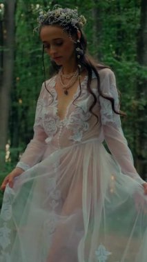 Dikey. Ormanda şeffaf beyaz elbiseli yalnız, çekici bir kadın. Çekici Dryad ya da Orman Perisi ruhani ve zarif bir şekilde ormanda geziniyor. Çıplak ayaklı orman perisi. Mavka Naiad Masalda