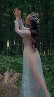 Dikey. Ormanda şeffaf beyaz elbiseli yalnız, çekici bir kadın. Çekici Dryad ya da Orman Perisi ruhani ve zarif bir şekilde ormanda geziniyor. Çıplak ayaklı orman perisi. Mavka Naiad Masalda