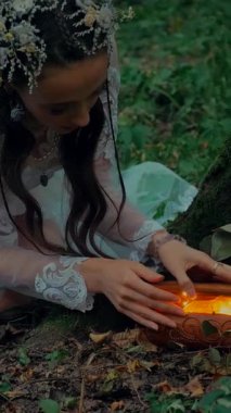 Dikey. Şeffaf beyaz elbiseli yalnız çekici kadın ormanda sihirli bir kutu açıyor. Çekici Dryad ya da Orman Perisi ruhani ve zarif bir şekilde ormanda geziniyor. Çıplak ayaklı orman perisi. Mavka Naiad Masalda