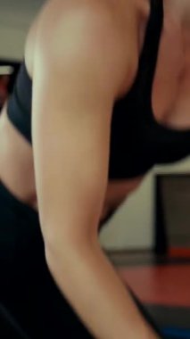 Dikey. Spor salonunda bir kadın, gücü ve hassasiyeti somutlaştırıyor. Ter parlıyor, kaslar çalışıyor. Bir bayan sporcu antrenman yapıyor, limitlerini zorluyor. Güçlü bir atletizm gösterisi. Güzel vücut şekilleri