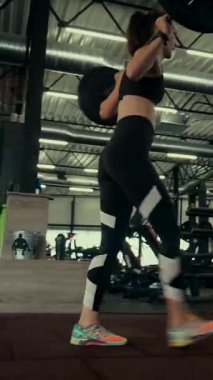 Dikey. Spor salonunda bir kadın, gücü ve hassasiyeti somutlaştırıyor. Ter parlıyor, kaslar çalışıyor. Bir bayan sporcu antrenman yapıyor, limitlerini zorluyor. Güçlü bir atletizm gösterisi. Güzel vücut şekilleri