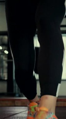 Dikey. Spor salonunda bir kadın, gücü ve hassasiyeti somutlaştırıyor. Ter parlıyor, kaslar çalışıyor. Bir bayan sporcu antrenman yapıyor, limitlerini zorluyor. Güçlü bir atletizm gösterisi. Güzel vücut şekilleri