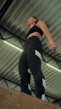 Dikey. Spor salonunda bir kadın, gücü ve hassasiyeti somutlaştırıyor. Ter parlıyor, kaslar çalışıyor. Bir bayan sporcu antrenman yapıyor, limitlerini zorluyor. Güçlü bir atletizm gösterisi. Güzel vücut şekilleri