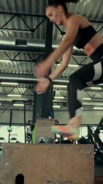 Dikey. Spor salonunda bir kadın, gücü ve hassasiyeti somutlaştırıyor. Ter parlıyor, kaslar çalışıyor. Bir bayan sporcu antrenman yapıyor, limitlerini zorluyor. Güçlü bir atletizm gösterisi. Güzel vücut şekilleri