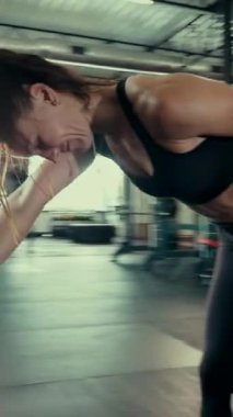 Dikey. Spor salonunda bir kadın, gücü ve hassasiyeti somutlaştırıyor. Ter parlıyor, kaslar çalışıyor. Bir bayan sporcu antrenman yapıyor, limitlerini zorluyor. Güçlü bir atletizm gösterisi. Güzel vücut şekilleri