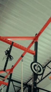 Dikey. Spor salonunda bir kadın, gücü ve hassasiyeti somutlaştırıyor. Ter parlıyor, kaslar çalışıyor. Bir bayan sporcu antrenman yapıyor, limitlerini zorluyor. Güçlü bir atletizm gösterisi. Güzel vücut şekilleri