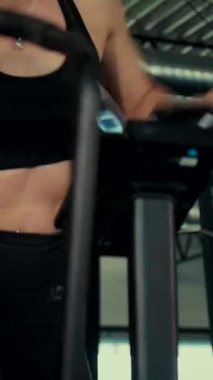 Dikey. Spor salonunda bir kadın, gücü ve hassasiyeti somutlaştırıyor. Ter parlıyor, kaslar çalışıyor. Bir bayan sporcu antrenman yapıyor, limitlerini zorluyor. Güçlü bir atletizm gösterisi. Güzel vücut şekilleri