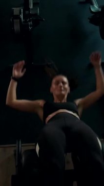 Dikey. Spor salonunda bir kadın, gücü ve hassasiyeti somutlaştırıyor. Ter parlıyor, kaslar çalışıyor. Bir bayan sporcu antrenman yapıyor, limitlerini zorluyor. Güçlü bir atletizm gösterisi. Güzel vücut şekilleri
