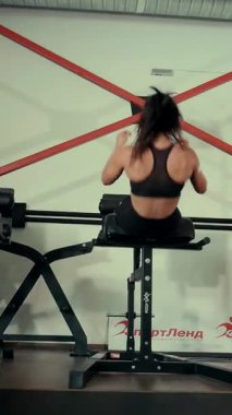 Dikey. Spor salonunda bir kadın, gücü ve hassasiyeti somutlaştırıyor. Ter parlıyor, kaslar çalışıyor. Bir bayan sporcu antrenman yapıyor, limitlerini zorluyor. Güçlü bir atletizm gösterisi. Güzel vücut şekilleri