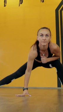 Dikey. Spor salonunda bir kadın, gücü ve hassasiyeti somutlaştırıyor. Ter parlıyor, kaslar çalışıyor. Bir bayan sporcu antrenman yapıyor, limitlerini zorluyor. Güçlü bir atletizm gösterisi. Güzel vücut şekilleri