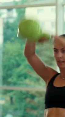 Dikey. Spor salonunda bir kadın, gücü ve hassasiyeti somutlaştırıyor. Ter parlıyor, kaslar çalışıyor. Bir bayan sporcu antrenman yapıyor, limitlerini zorluyor. Güçlü bir atletizm gösterisi. Güzel vücut şekilleri