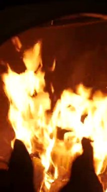 Dikey. Karmaşık, süslü eski şömine, oyulmuş açıklıklarda dans eden alevler. Yangından yayılan sıcaklık, yontulmuş bir şöminenin içinde. Kale şöminesinde şömine, soba..