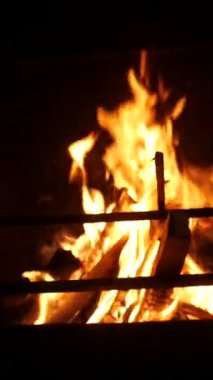 Dikey. Karmaşık, süslü eski şömine, oyulmuş açıklıklarda dans eden alevler. Yangından yayılan sıcaklık, yontulmuş bir şöminenin içinde. Kale şöminesinde şömine, soba..