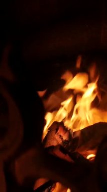 Dikey. Karmaşık, süslü eski şömine, oyulmuş açıklıklarda dans eden alevler. Yangından yayılan sıcaklık, yontulmuş bir şöminenin içinde. Kale şöminesinde şömine, soba..