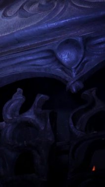 Dikey. Karmaşık, süslü eski şömine, oyulmuş açıklıklarda dans eden alevler. Yangından yayılan sıcaklık, yontulmuş bir şöminenin içinde. Kale şöminesinde şömine, soba..